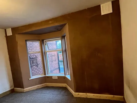 Bay window wall freshly replastered after penetrating damp treatment